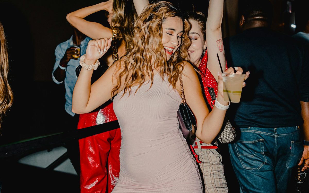 Oameni care dansează la o petrecere, în lumină de club